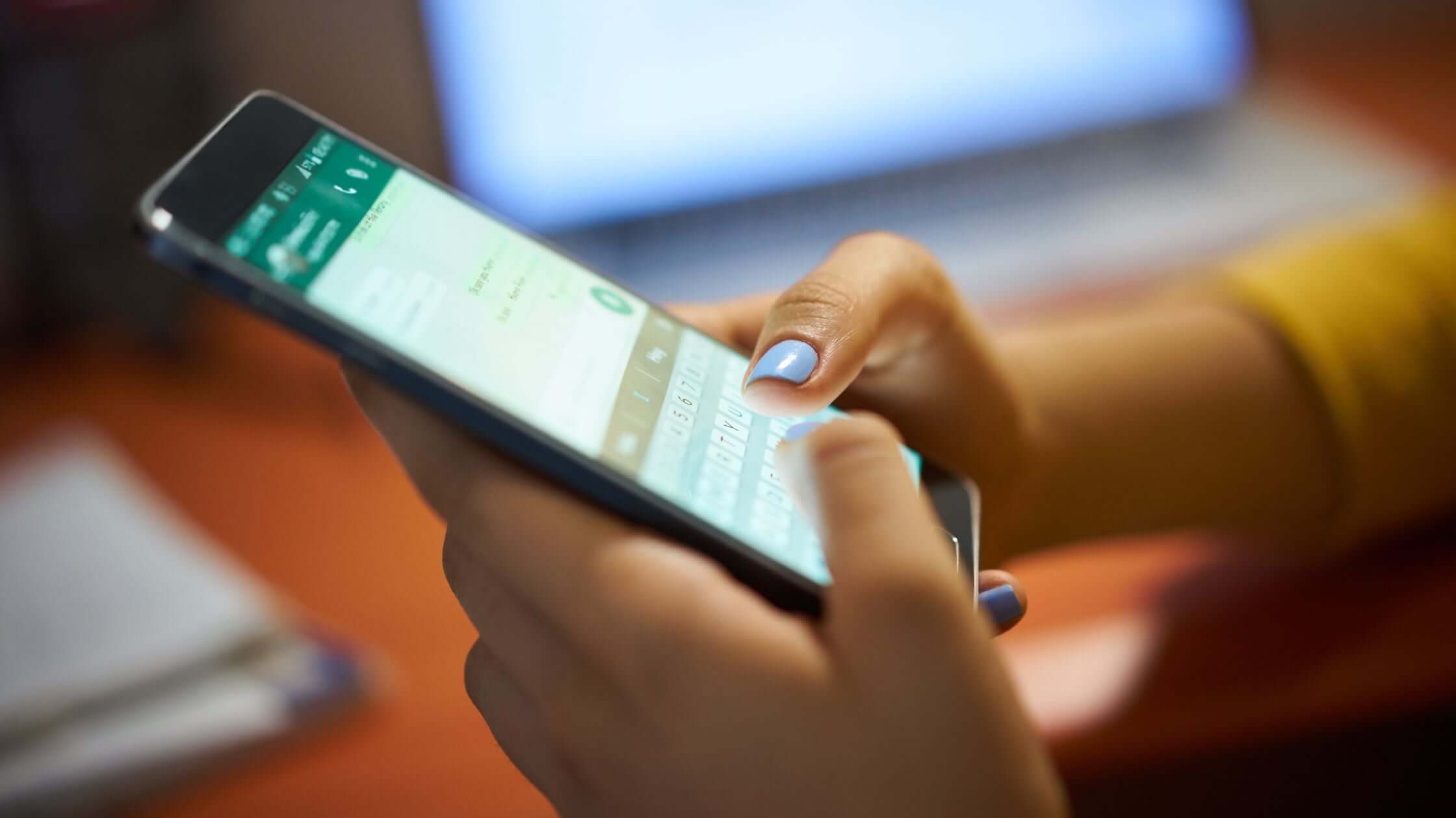 Hands typing a customer reply in WhatsApp, a common WhatsApp automation use case